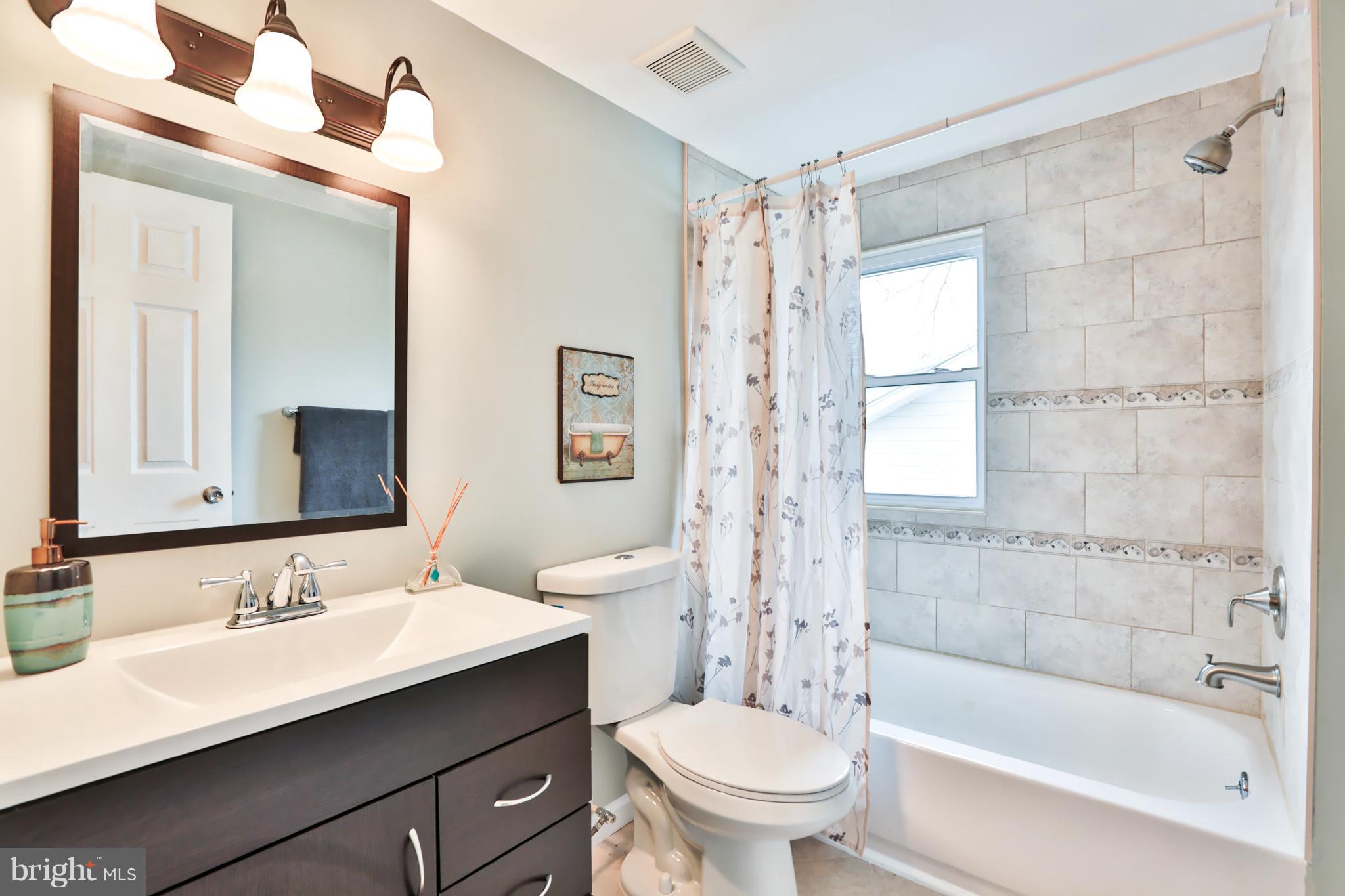 3710 Barrington Road Baltimore, MD 21215 - Photo 14 of 25 a bathroom with a sink toilet a mirror and shower