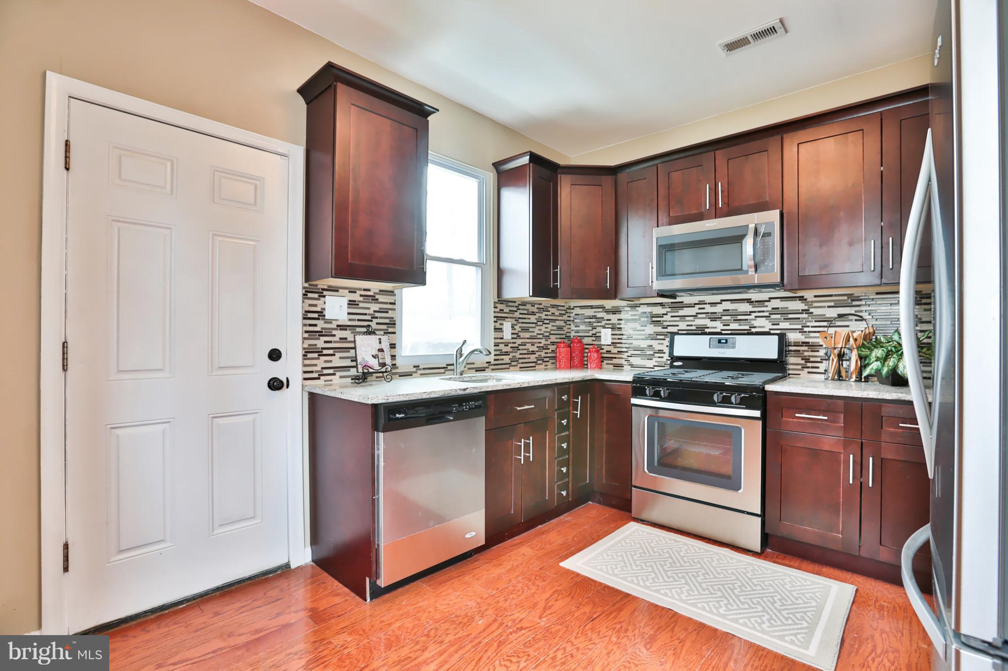 3710 Barrington Road Baltimore, MD 21215 - Photo 6 of 25 a kitchen with stainless steel appliances granite countertop a stove a sink and a microwave