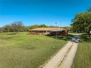 a view of a swimming pool with lawn chairs under an umbrella