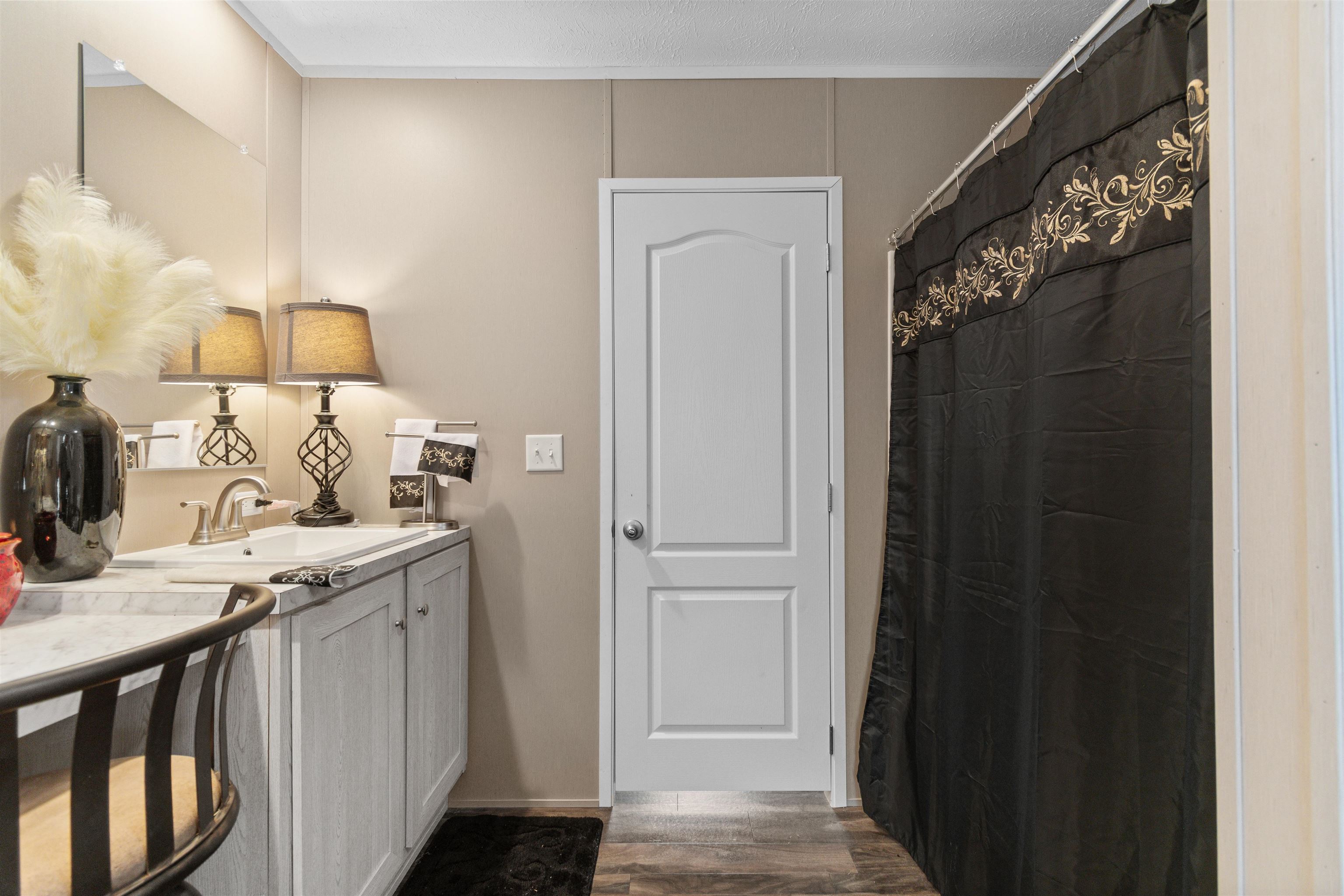 2482 Wigley Road Loris, SC 29569 - Photo 25 of 39 Bar area with light countertops, ornamental molding, dark wood-style floors, and white cabinetry