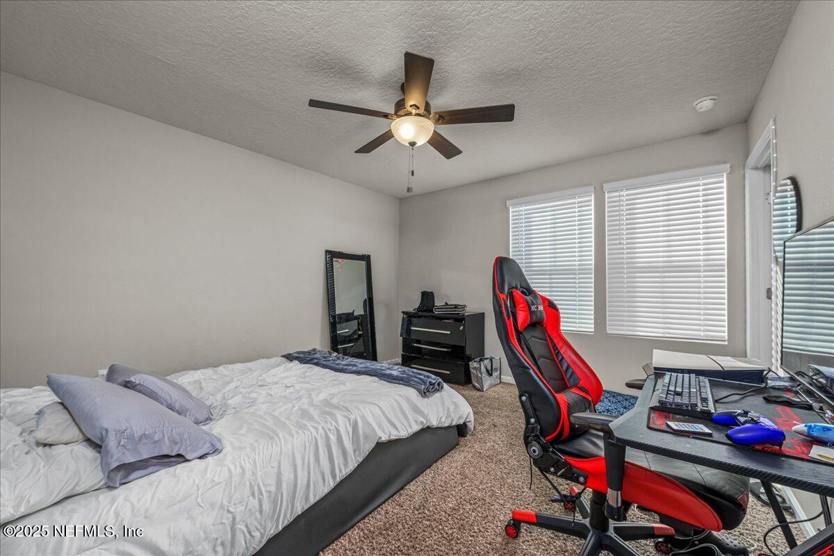 3557 Grayson Lane Middleburg, FL 32068 - Photo 9 of 18 a bed room with a bed a desk and a chandelier