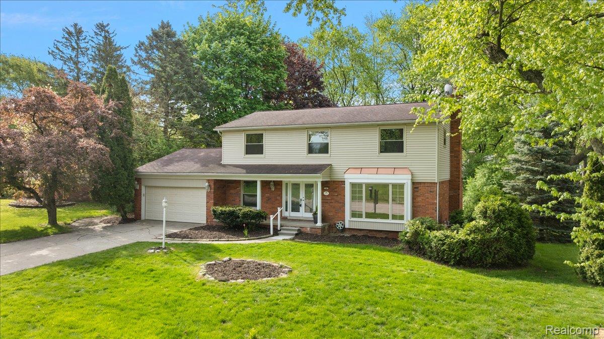 536 Rolling Rock Road Bloomfield Hills, MI 48304 - Photo 1 of 48 Traditional-style home featuring a front lawn, brick siding, concrete driveway, a garage, and a porch