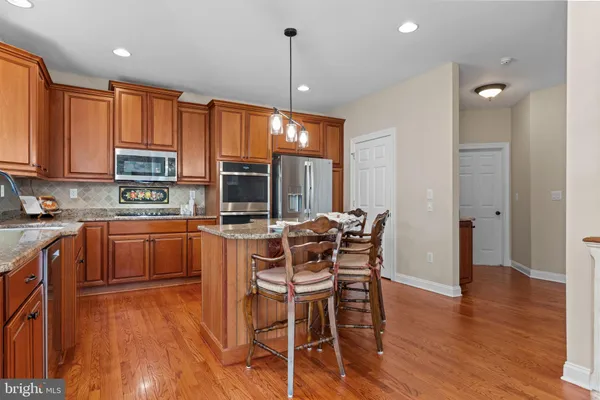 a kitchen with stainless steel appliances granite countertop a refrigerator and a stove top oven
