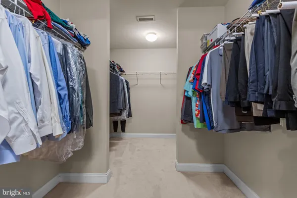 an empty room with a fan and a chandelier fan
