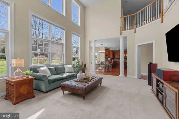 a kitchen with stainless steel appliances granite countertop a stove a refrigerator a sink a dining table and chairs with wooden floor