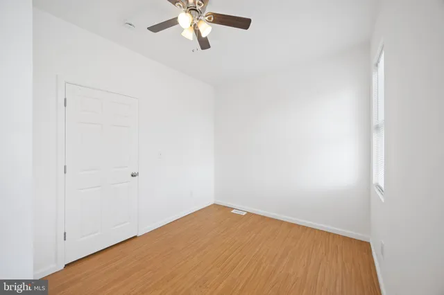an empty room with a window and a fan