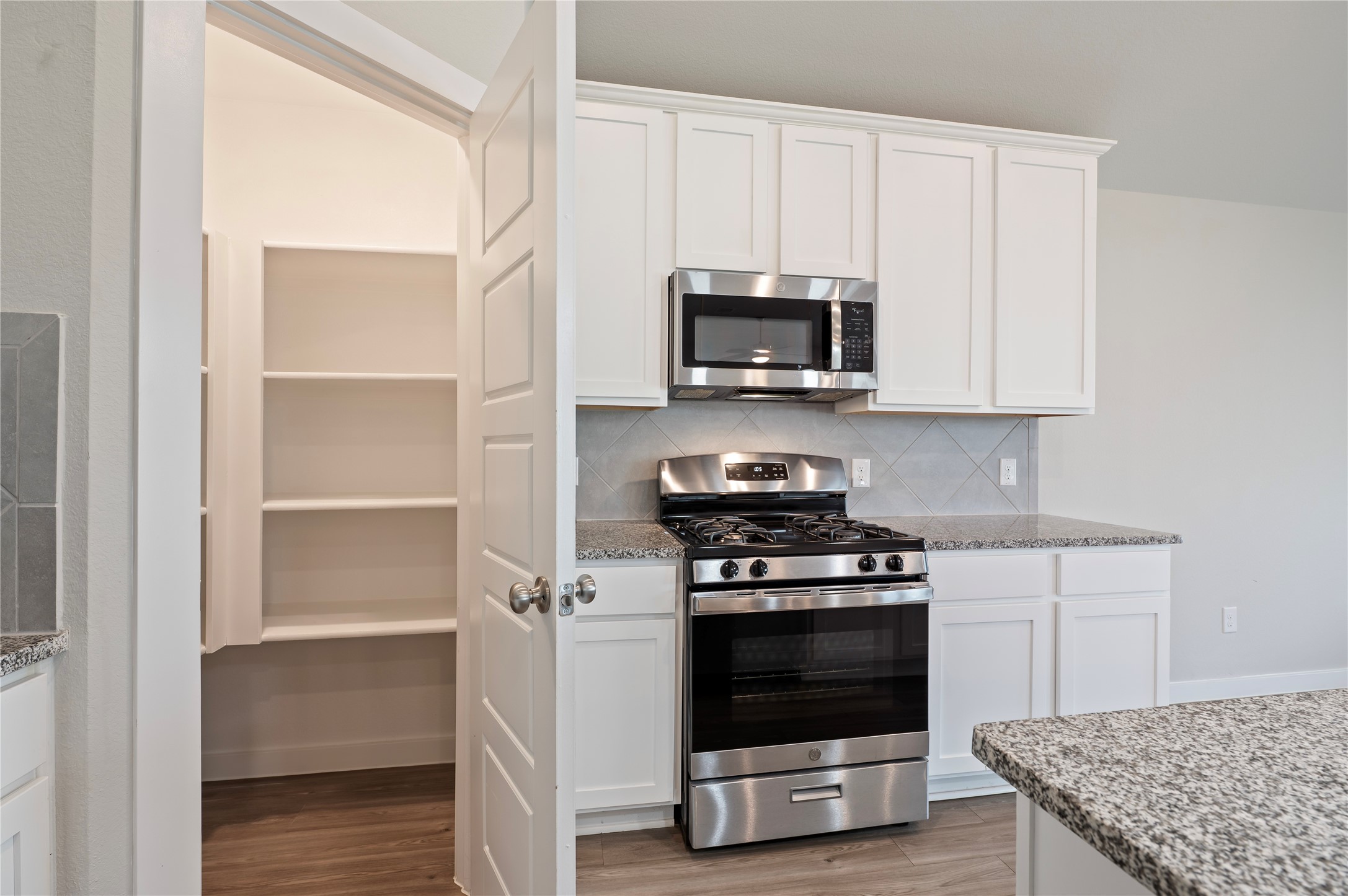 2107 Santa Ana Way Baytown, TX 77523 - Photo 9 of 40 a kitchen with white cabinets and stainless steel appliances
