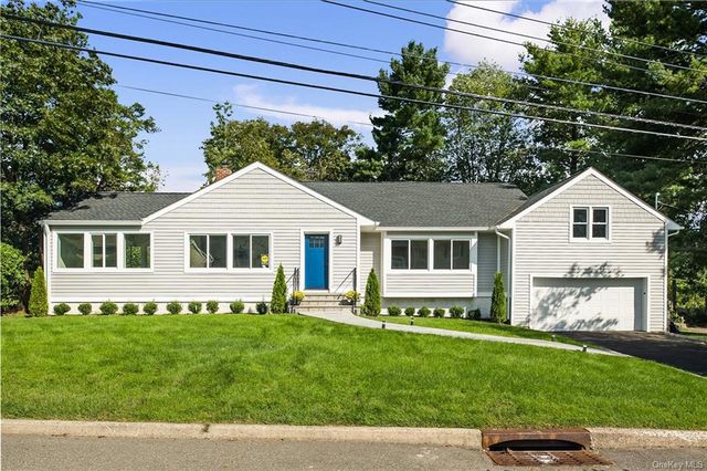 a front view of a house with a garden