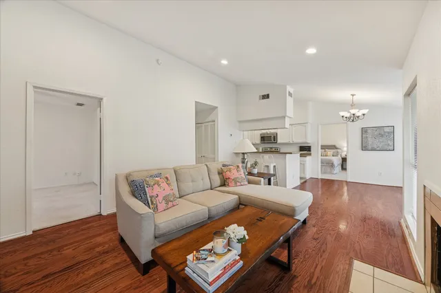 a living room with furniture and kitchen view with wooden floor