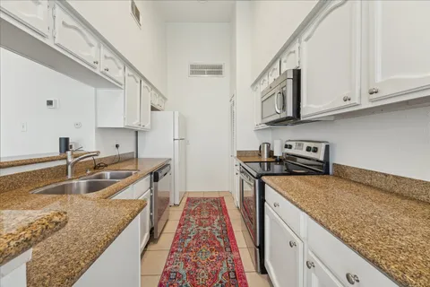 a kitchen with stainless steel appliances granite countertop a sink stove and cabinets
