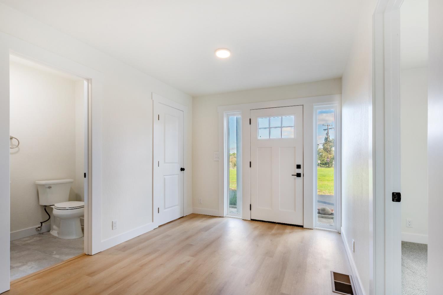 10020 Alta Mesa Road Wilton, CA 95693 - Photo 17 of 56 a view of a hallway with wooden floor and a bathroom