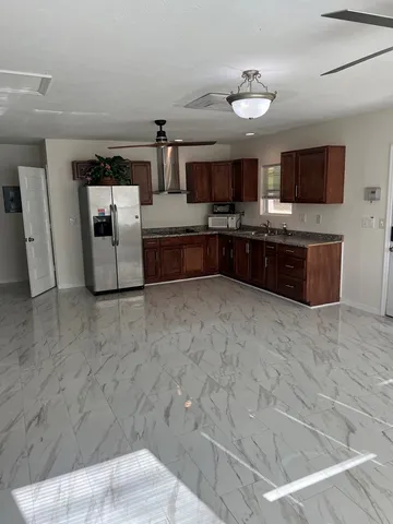 a large white kitchen with a stove a sink dishwasher and a microwave oven in a kitchen