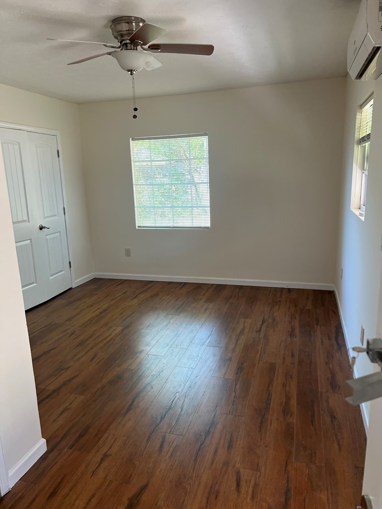 6528 Yellow Stone Court Columbus, GA 31909 - Photo 22 of 29 an empty room with wooden floor chandelier fan and windows