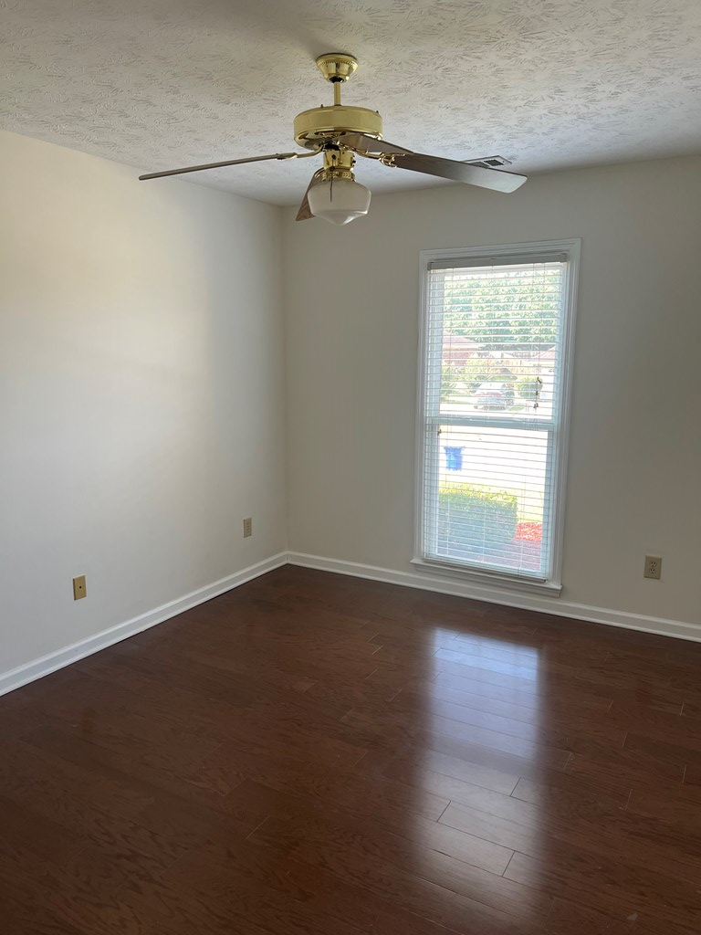 6528 Yellow Stone Court Columbus, GA 31909 - Photo 3 of 29 an empty room with wooden floor chandelier fan and windows