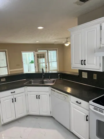 a kitchen with granite countertop white cabinets and a sink