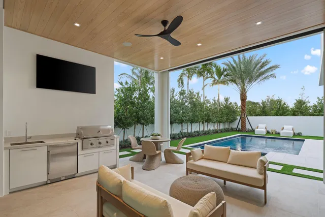 a large white kitchen with a large window and stainless steel appliances