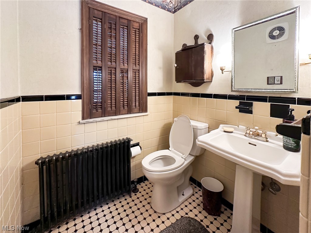 11911 County Line Road Chesterland, OH 44026 - Photo 29 of 49 Bathroom with radiator, tasteful backsplash, tile walls, toilet, and tile flooring