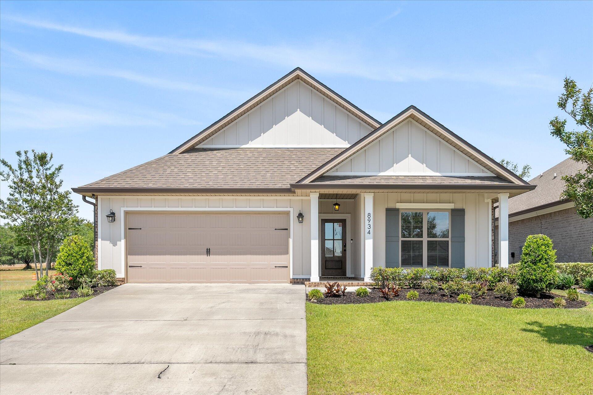 8934 Skip Stone Road Milton, FL 32583 - Photo 1 of 55 a front view of a house with a yard and garage