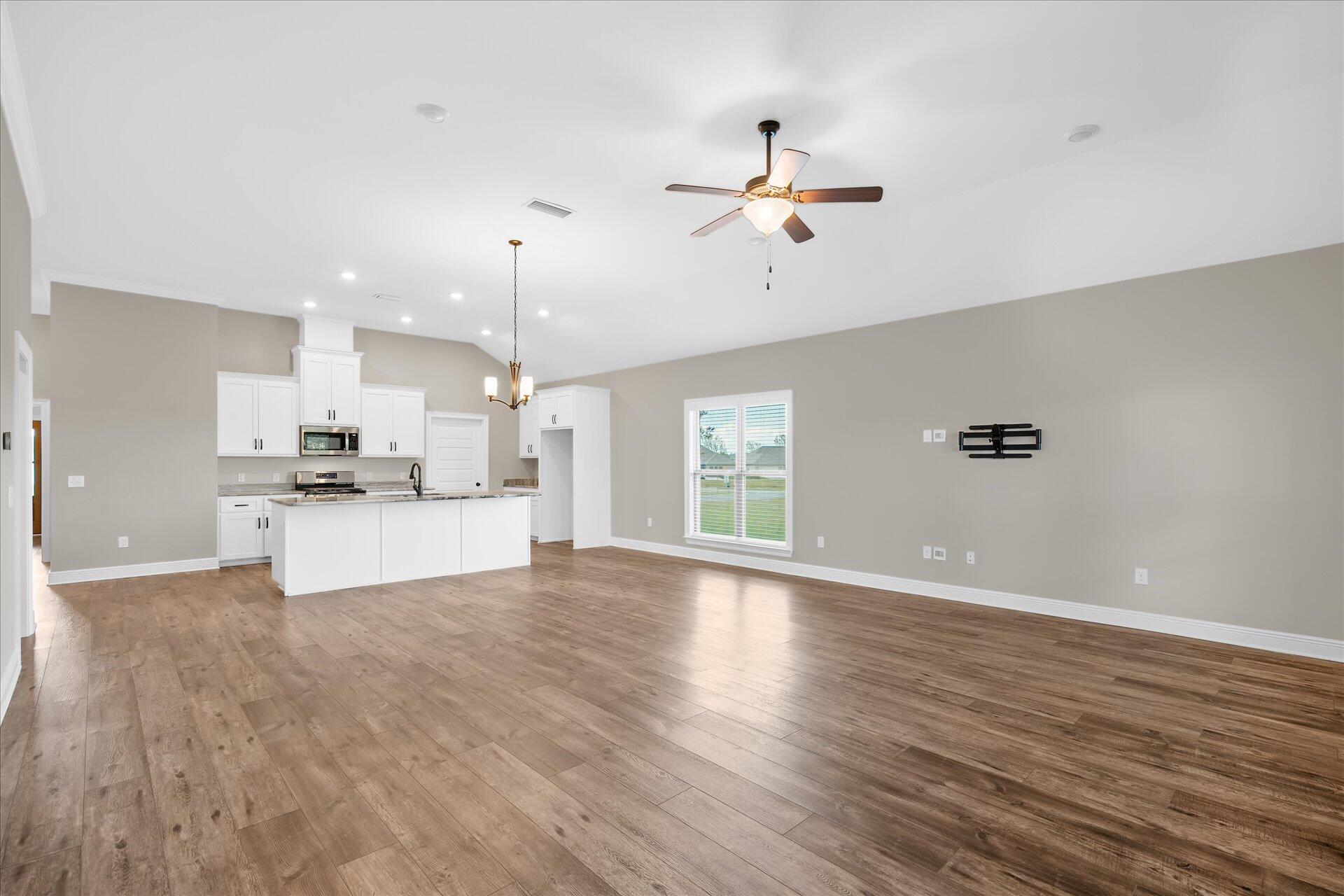 8934 Skip Stone Road Milton, FL 32583 - Photo 12 of 55 a view of a kitchen with a sink and dishwasher with wooden floor