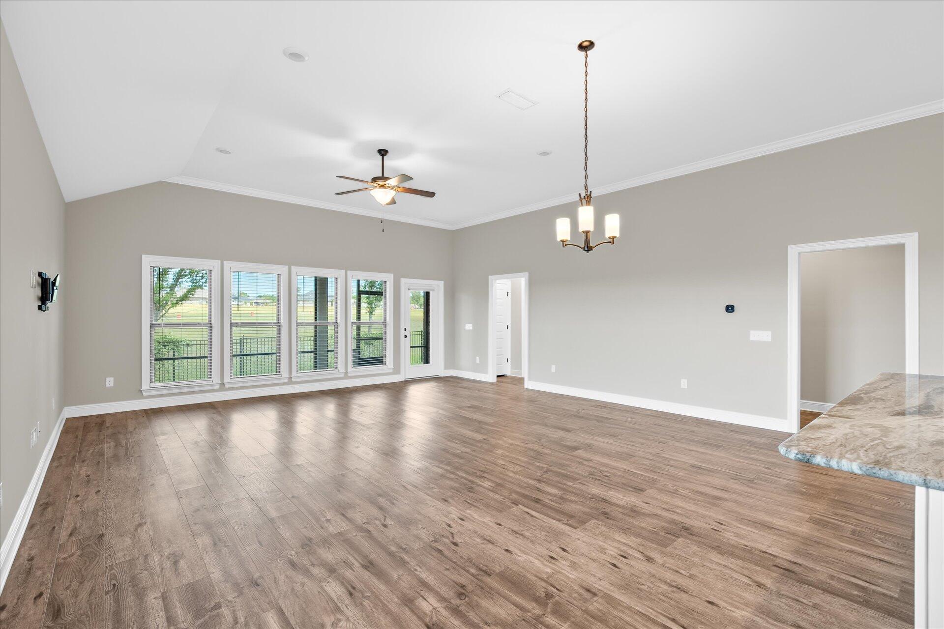 8934 Skip Stone Road Milton, FL 32583 - Photo 14 of 55 a view of an empty room with wooden floor and a window