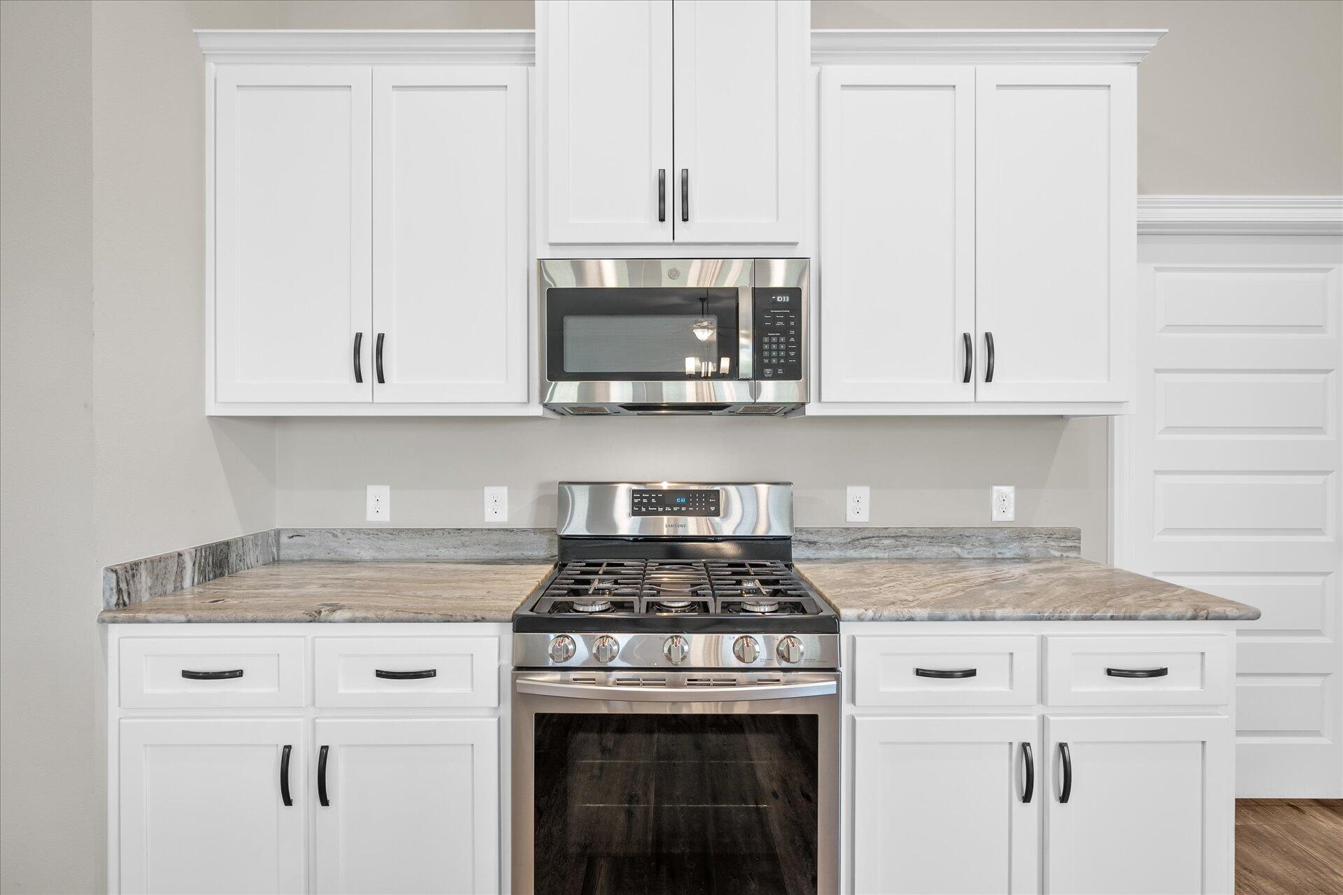 8934 Skip Stone Road Milton, FL 32583 - Photo 20 of 55 a kitchen with granite countertop white cabinets and a stove