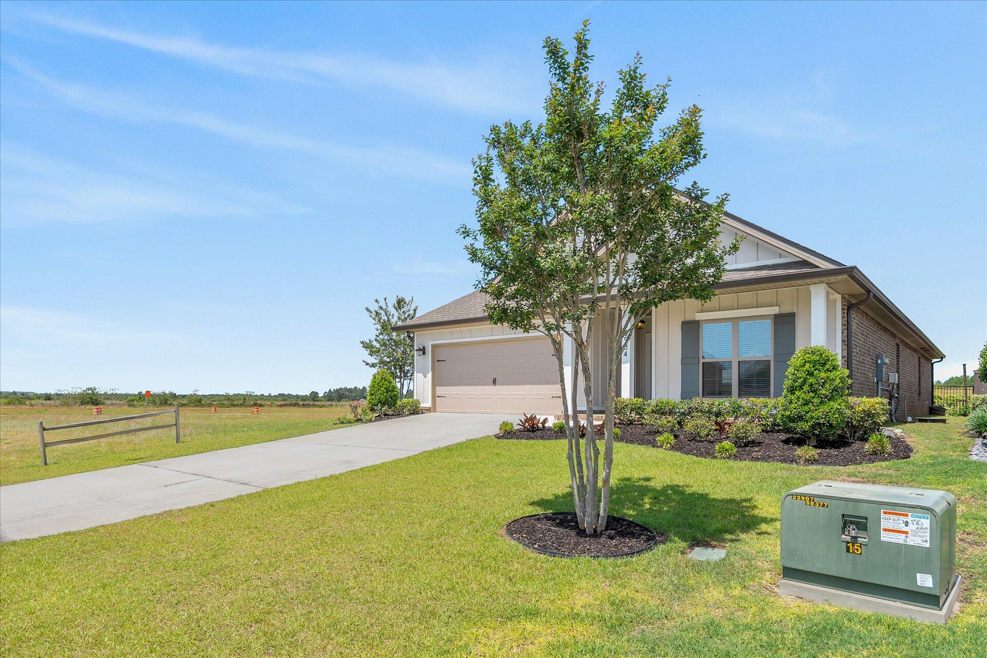 8934 Skip Stone Road Milton, FL 32583 - Photo 2 of 55 a front view of a house with a yard and garage