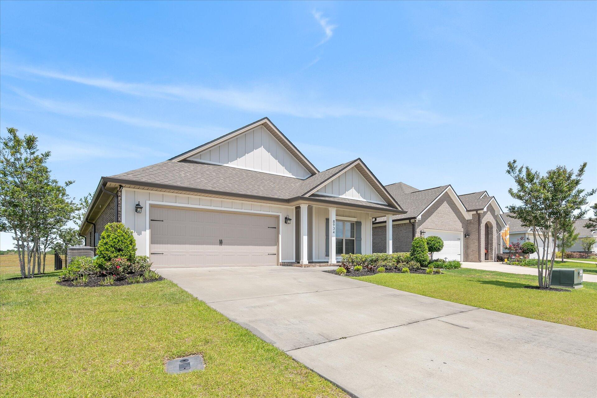 8934 Skip Stone Road Milton, FL 32583 - Photo 3 of 55 a front view of a house with a yard and garage