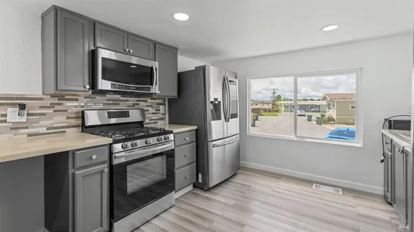 a kitchen with stainless steel appliances a stove microwave and refrigerator