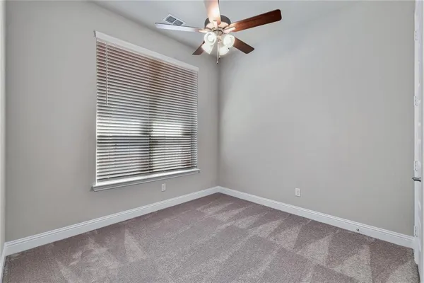 an empty room with a window and a fan