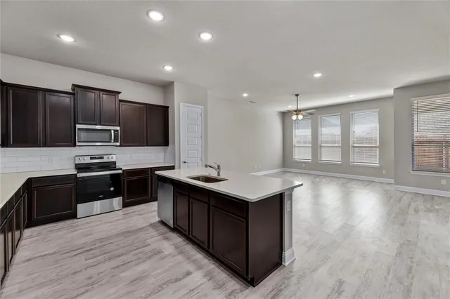 a kitchen with stainless steel appliances granite countertop a stove a sink and a refrigerator