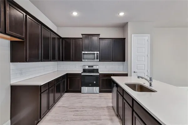 a kitchen with a sink stove and refrigerator