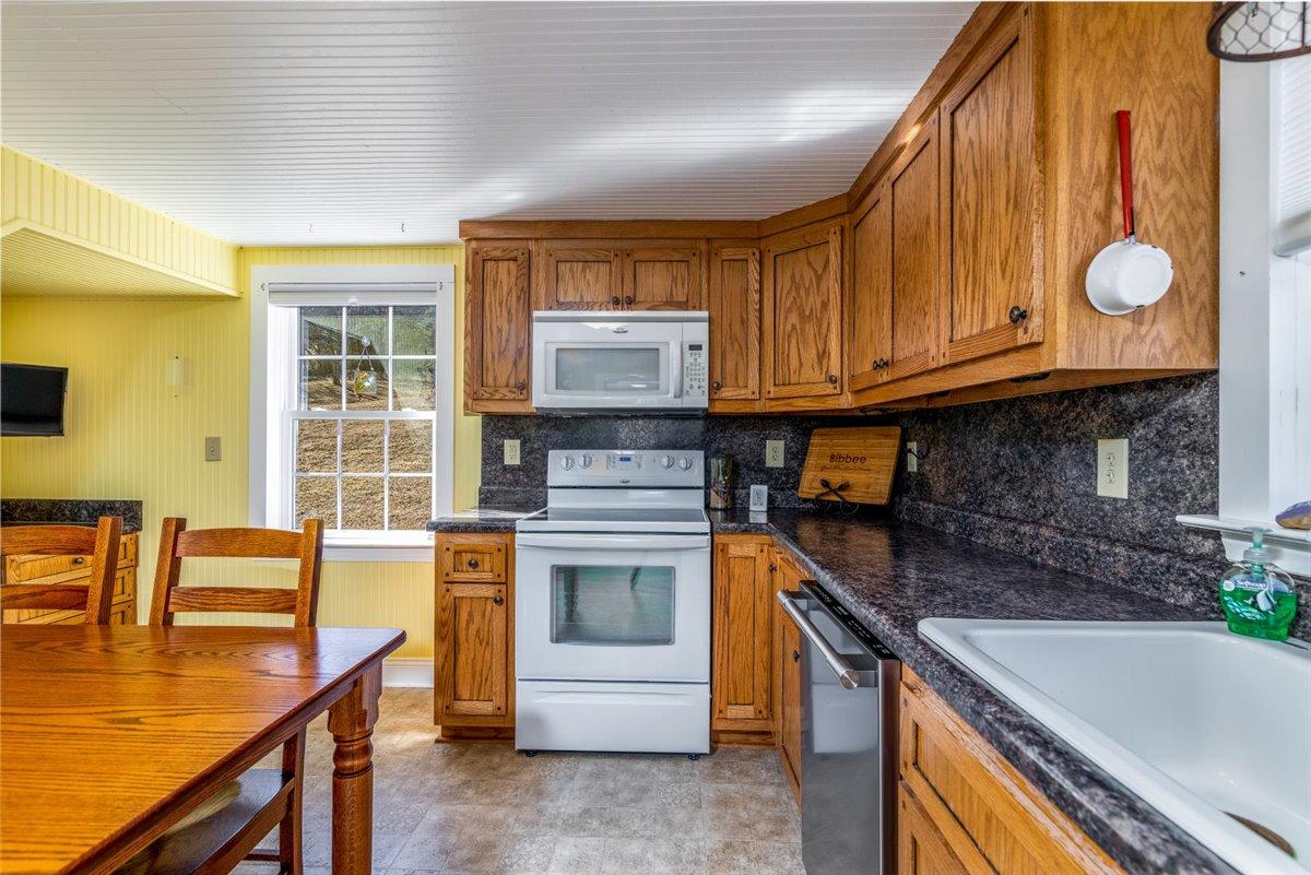 2717 Thompson Ridge Road Ferrum, VA 24088 - Photo 7 of 25 a kitchen with granite countertop a stove a sink and a microwave