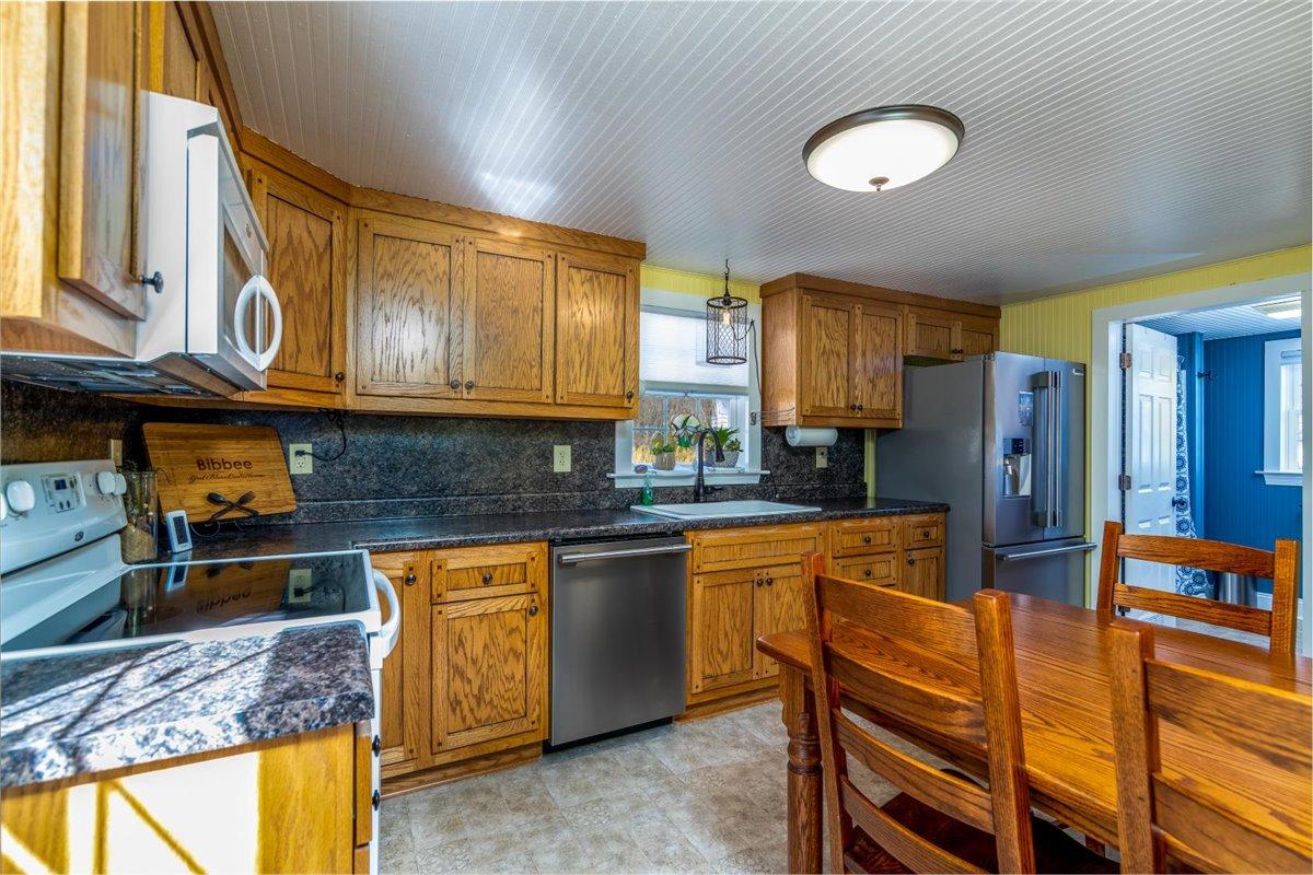 2717 Thompson Ridge Road Ferrum, VA 24088 - Photo 9 of 25 a kitchen with stainless steel appliances granite countertop wooden cabinets a sink dishwasher a stove and a refrigerator with wooden floor