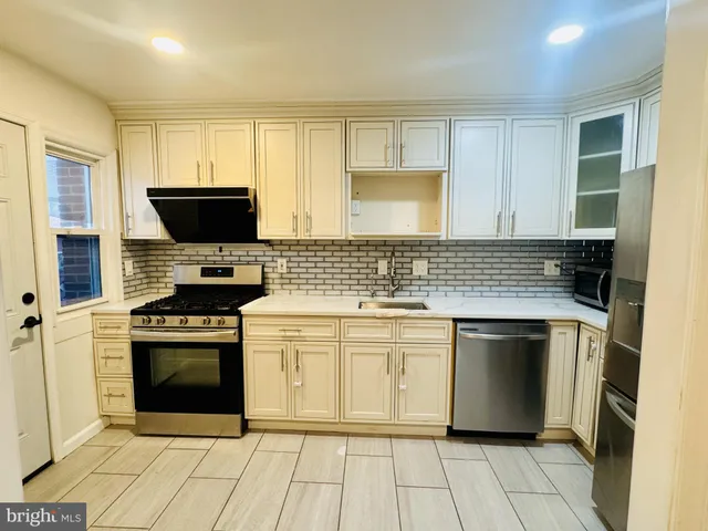 a kitchen with granite countertop a stove sink and cabinets