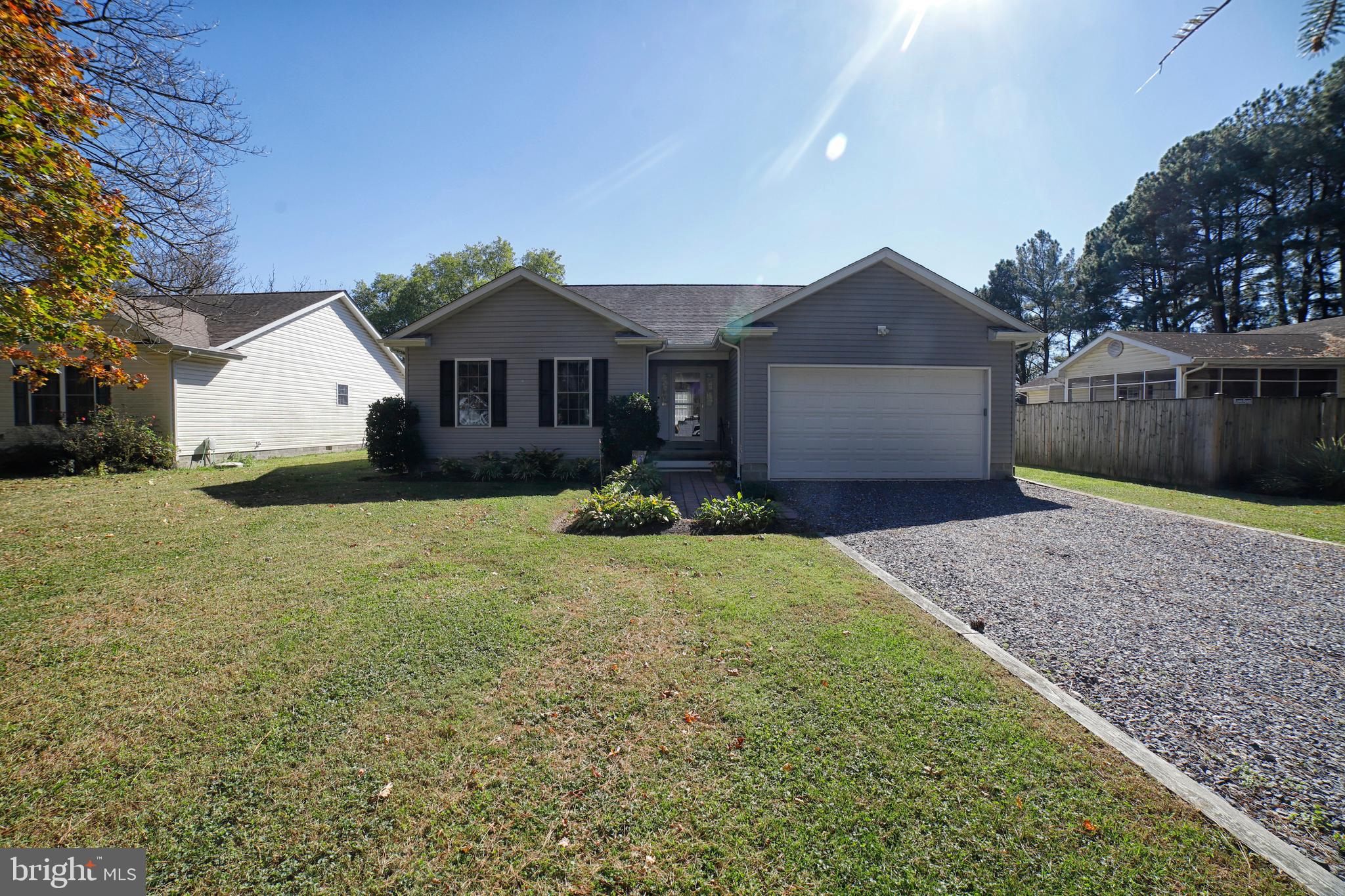 a front view of a house with a yard and large tree