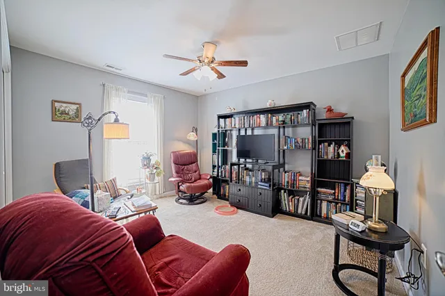 a bedroom with furniture a ceiling fan and a window