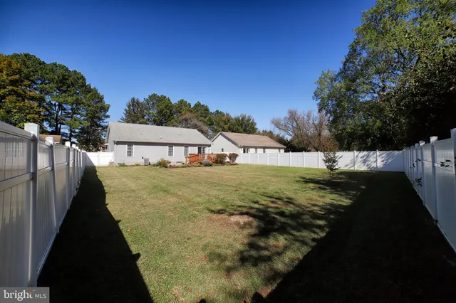 a view of a house with backyard and trees
