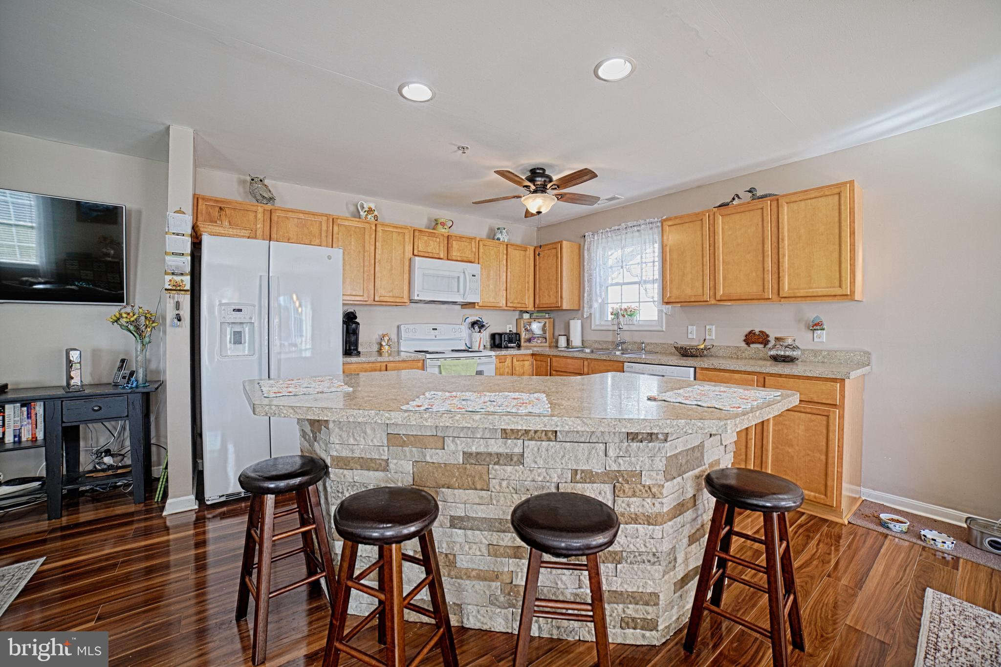 130 Walnut Street Ridgely, MD 21660 - Photo 10 of 27 a kitchen with stainless steel appliances granite countertop a stove top oven a refrigerator a sink and a dining table with chairs