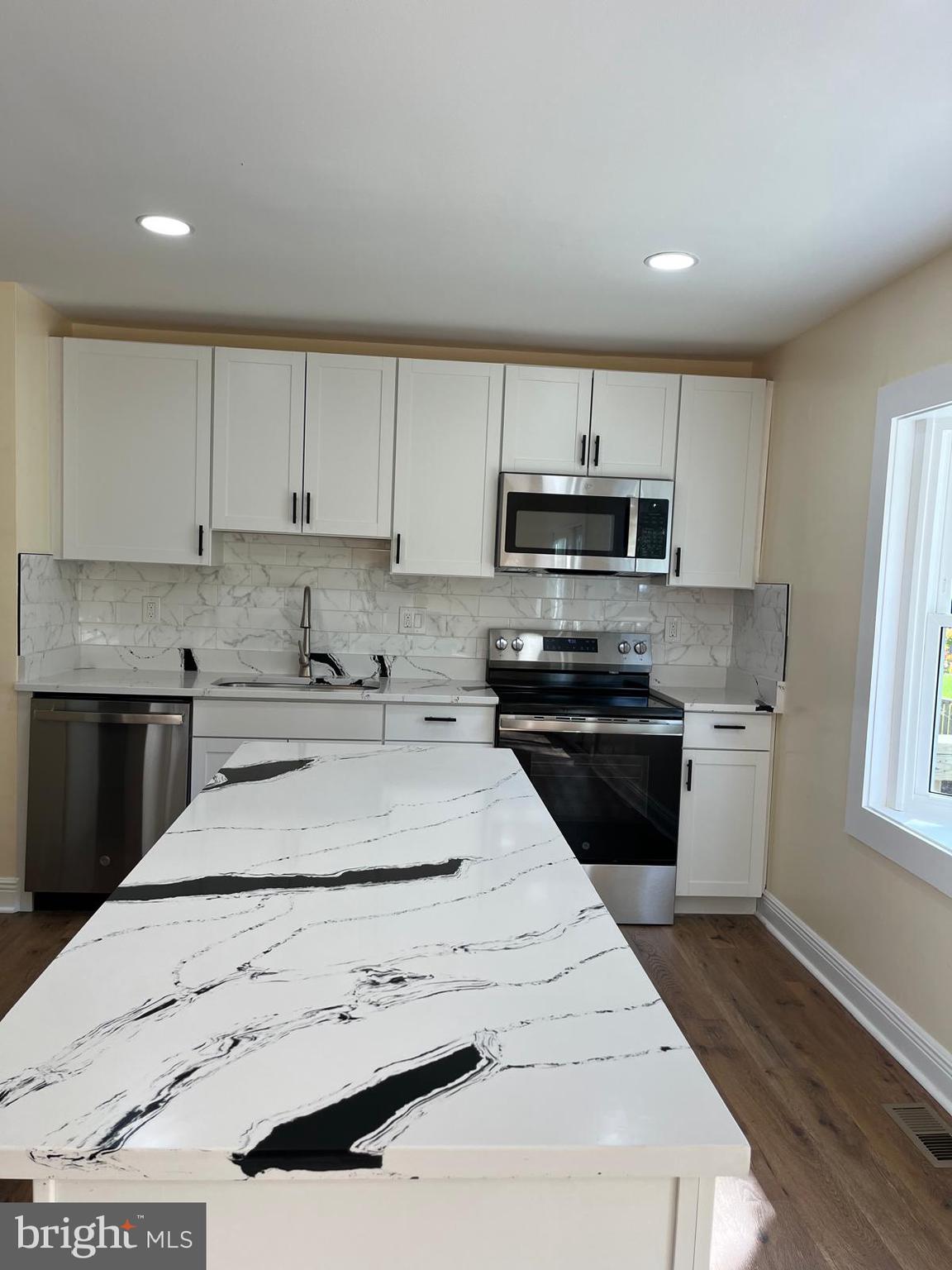 6706 Surratts Road Clinton, MD 20735 - Photo 3 of 24 a kitchen with granite countertop white cabinets and stainless steel appliances