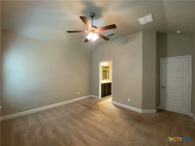 an empty room with closet and a chandelier fan