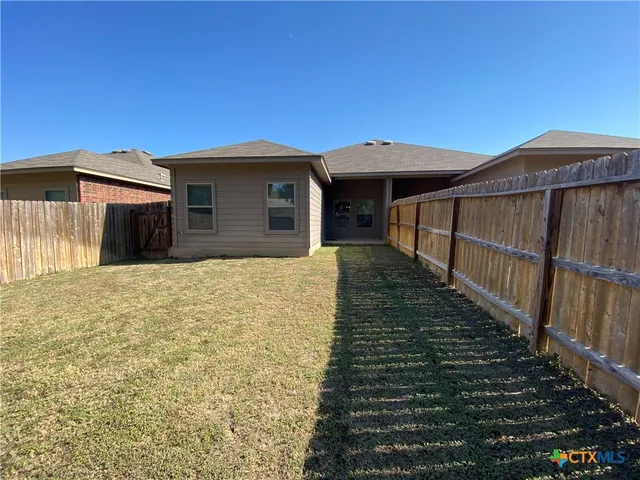 a view of a house with wooden fence