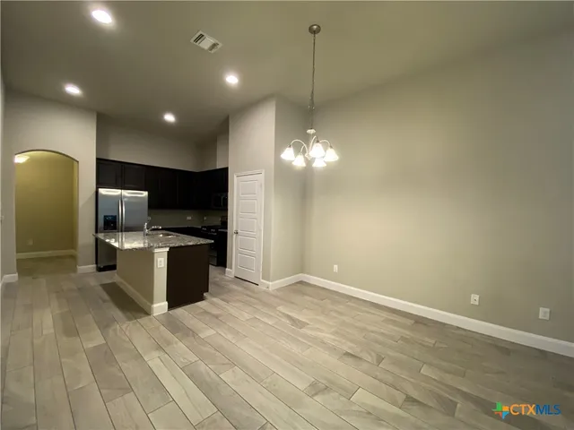 a large kitchen with kitchen island a sink stainless steel appliances and a fireplace