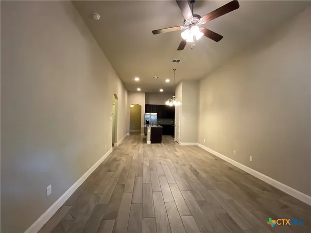 a view of empty room with wooden floor