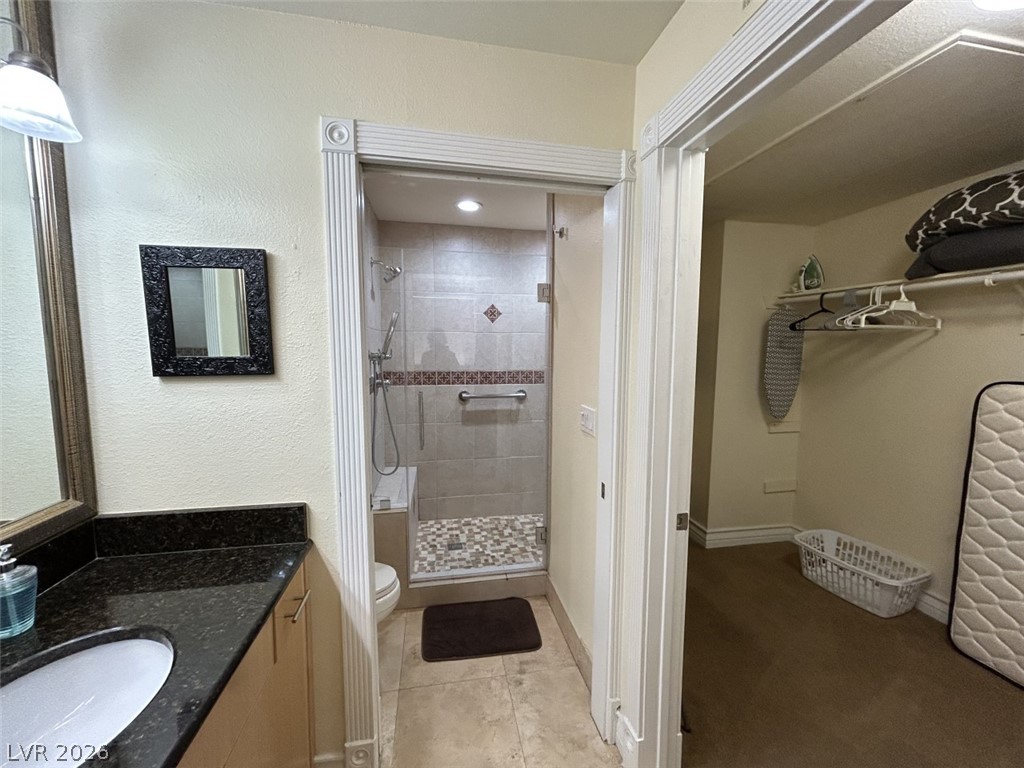 210 East Flamingo Road, Unit 137 Las Vegas, NV 89169 - Photo 17 of 32 Granite counters complement the inviting bathroom, leading to a generously sized walk-in closet.