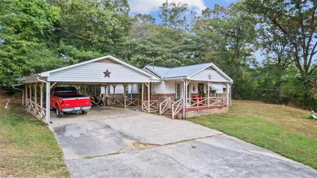 a view of a house with a yard and sitting area