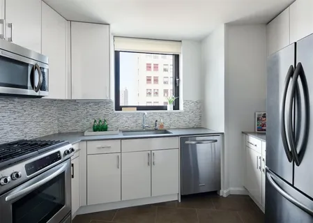 a kitchen with appliances a sink and a window