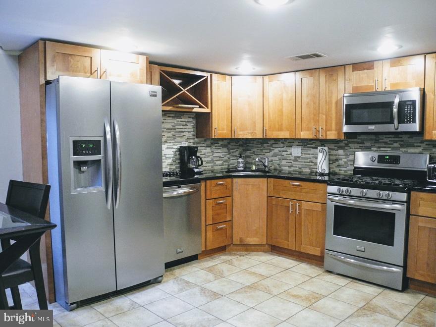 a kitchen with stainless steel appliances granite countertop a refrigerator stove and microwave