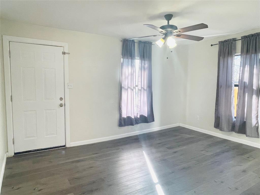 111 Rousseau Street Waxahachie, TX 75165 - Photo 5 of 22 an empty room with wooden floor window and closet area