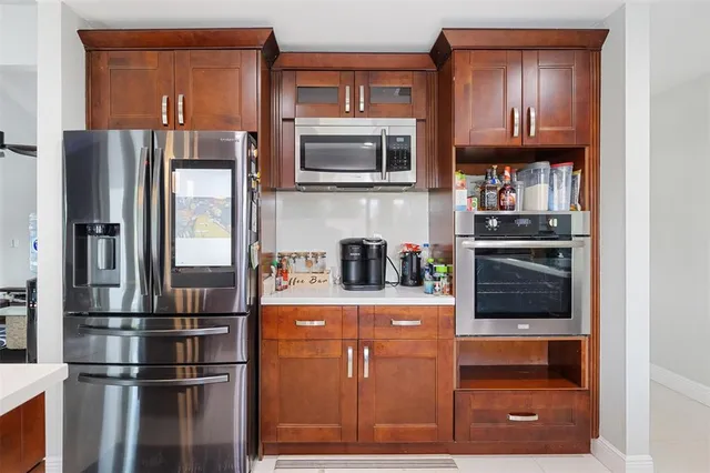 a kitchen with stainless steel appliances granite countertop a refrigerator and a stove top oven
