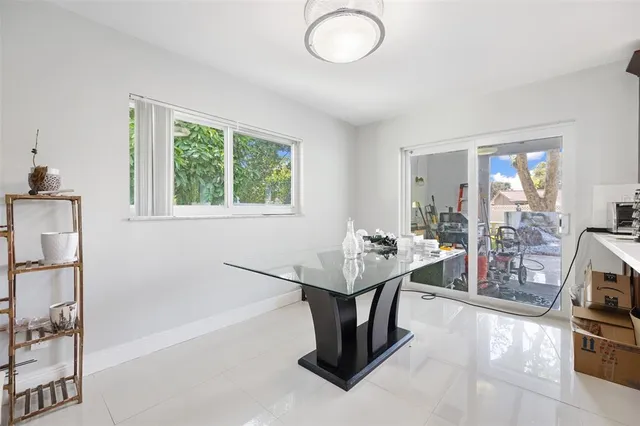 a dining room with furniture and a floor to ceiling window